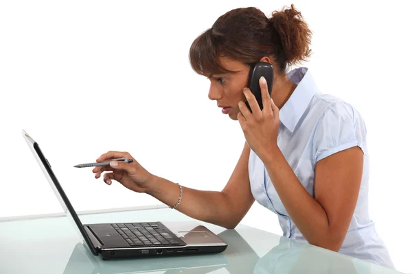 Γυναίκα στο τηλέφωνο μπροστά από τον υπολογιστή — Φωτογραφία Αρχείου