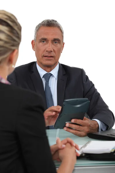 Geschäftsmann mit Taschenrechner im Gespräch mit seinem Mitarbeiter — Stockfoto