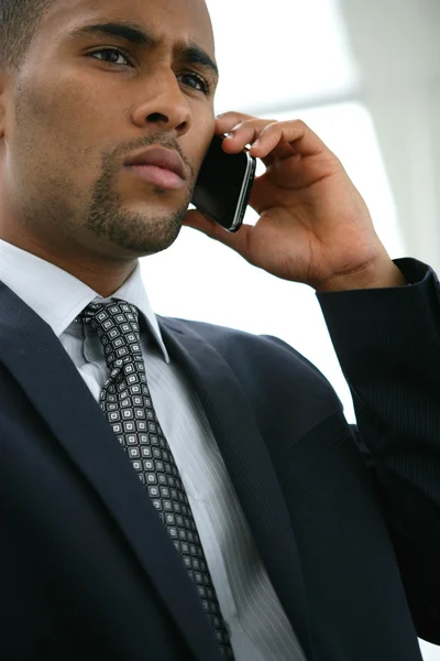 Серьезный бизнесмен, пользующийся мобильным телефоном — стоковое фото