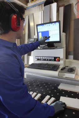 Man stood by computer operated factory machine clipart