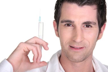 Dark-haired man holding syringe clipart