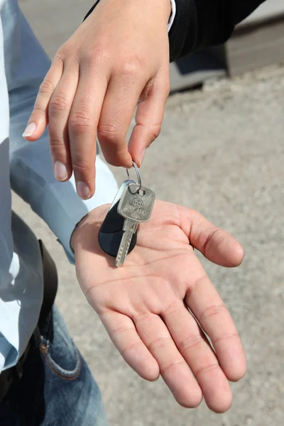 Verkäuferin übergibt Schlüssel an Mann — Stockfoto