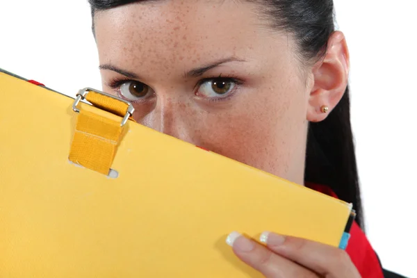 Woman hiding behind a folder — Stock Photo, Image