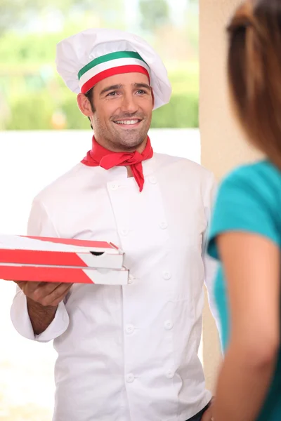 Man levererar nybakade pizzor — Stockfoto