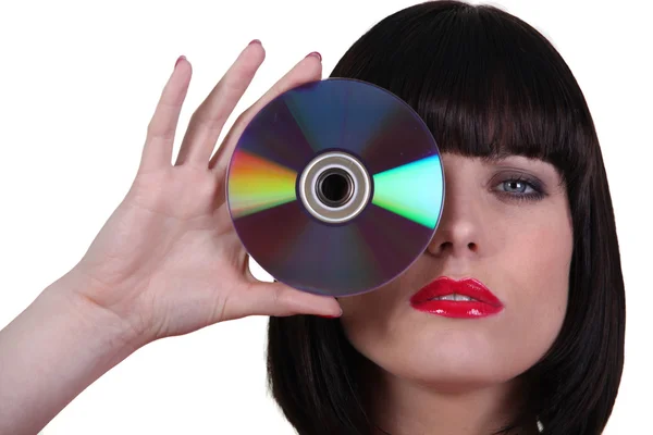 Frau hält eine CD an ihr Auge — Stockfoto