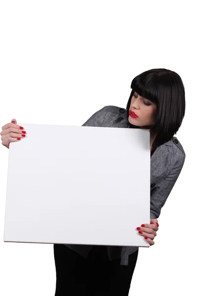 Mujer joven sosteniendo panel blanco — Foto de Stock