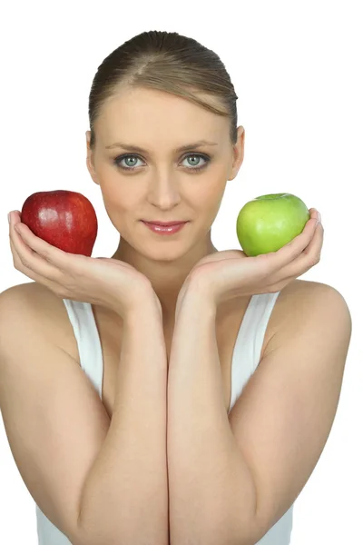 Young woman holding a red and a green apple — Stock Photo, Image