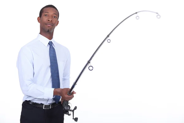 Man in a shirt and tie using a fishing rod — Stock Photo, Image