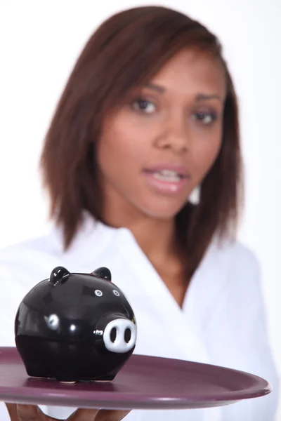 Woman carrying piggy-bank on tray — Stock Photo, Image