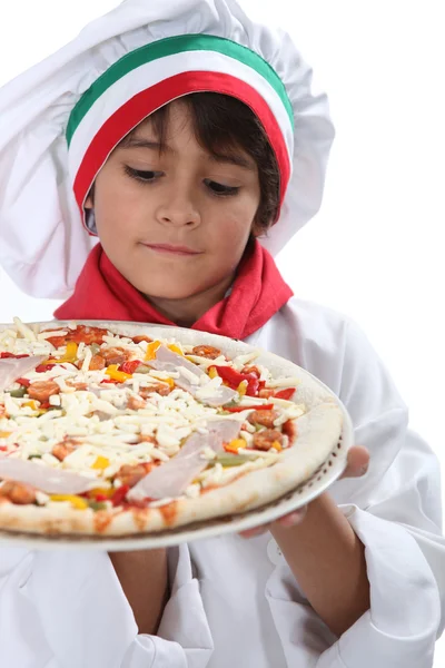 Ung pojke låtsas en vara en pizzabagare — Stockfoto