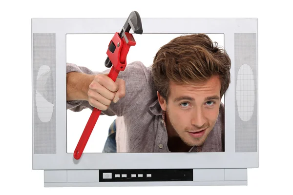 Plumber coming out of the television — Stock Photo, Image