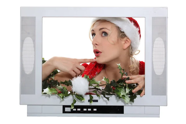 Mulher com chapéu de Natal atrás da moldura da televisão — Fotografia de Stock