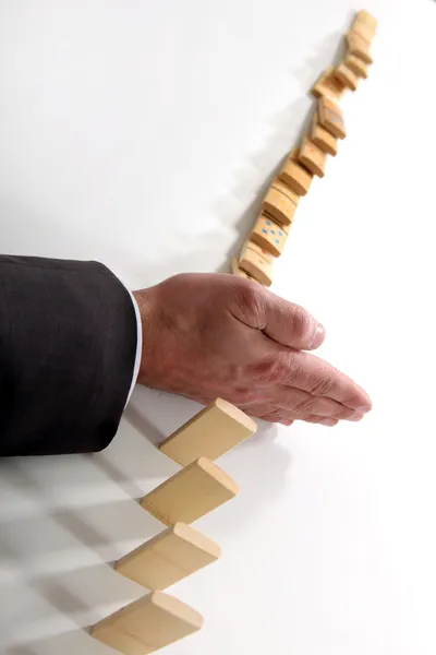Uomo d'affari con una linea di domino — Foto Stock