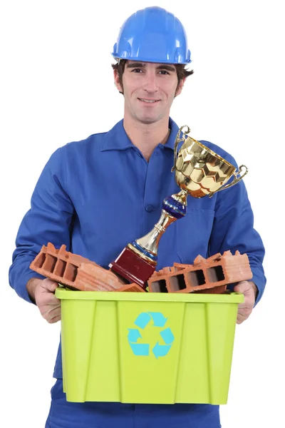 Construtor com um prêmio para reciclagem de material — Fotografia de Stock