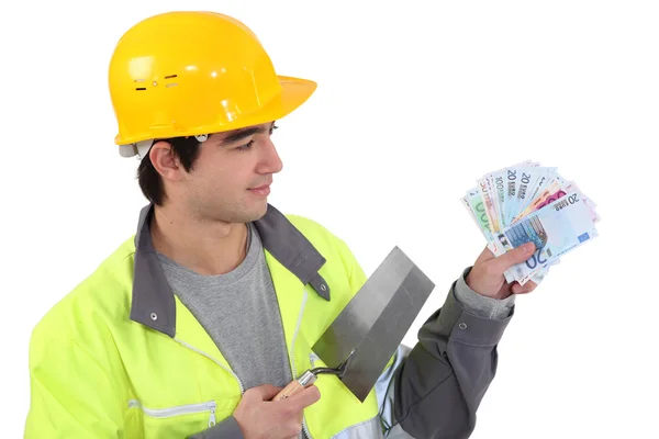 Young builder with a handful of cash — Stock Photo, Image
