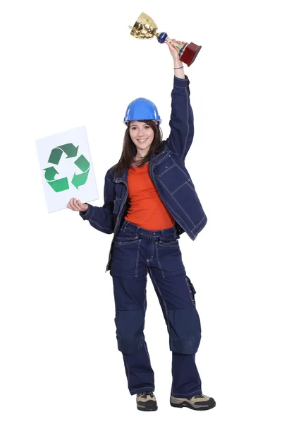 Θηλυκό οικοδόμος κρατώντας τρόπαιο και ανακύκλωση λογότυπο — Φωτογραφία Αρχείου
