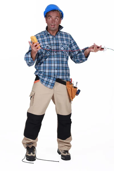 Ein Mann mit einem Elektroschocker, der einen Multitester hält — Stockfoto