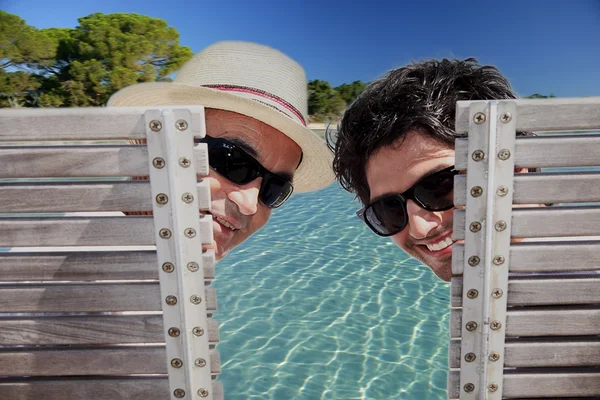 Vader en zoon zat aan het zwembad — Stockfoto