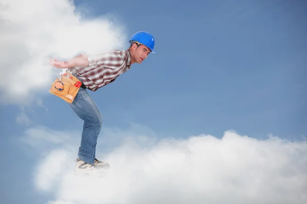 Fotomontage av en ung arbetare gå på molnen — Stockfoto
