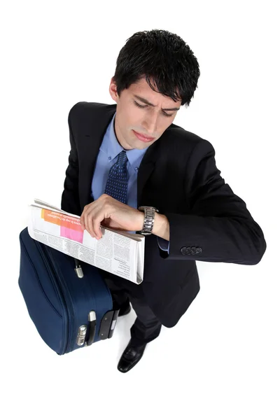 Affärsman med ett fall tittar på sin klocka — Stockfoto