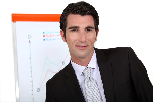 Businessman standing next to a flip chart — Stock Photo, Image