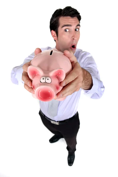 Ein Geschäftsmann hält ein Sparschwein. — Stockfoto