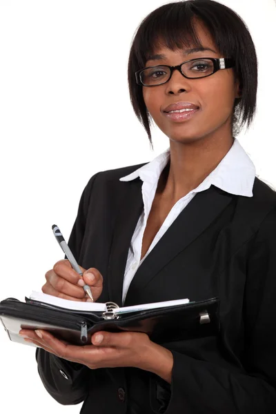 Uma mulher de negócios tomando notas sobre um planejador . — Fotografia de Stock