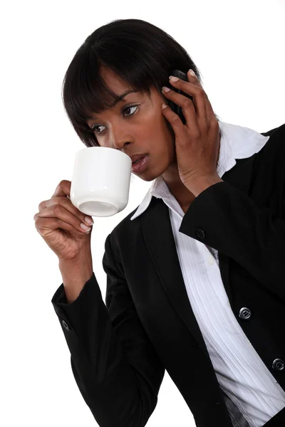 Afro-American affärskvinna talar på sin cell och dricker kaffe — Stockfoto