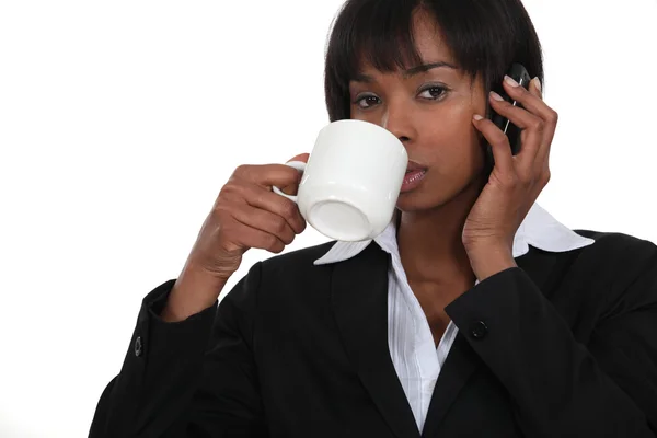 Affärskvinna dricka kaffe samtidigt på telefon — Stockfoto