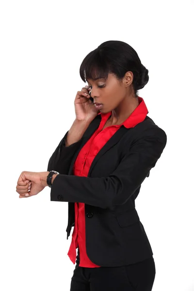 Una mujer de negocios afroamericana mirando su reloj . — Foto de Stock