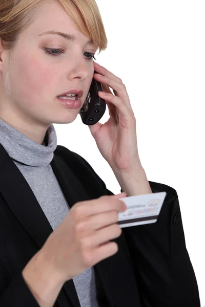 Empresária no telefone segurando cartão de crédito — Fotografia de Stock