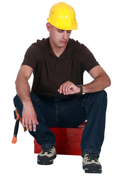 A janitor staring at his watch. — Stock Photo, Image