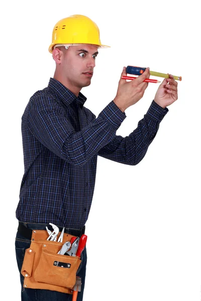 Man looking at his measuring tape surprisingly — Stock Photo, Image
