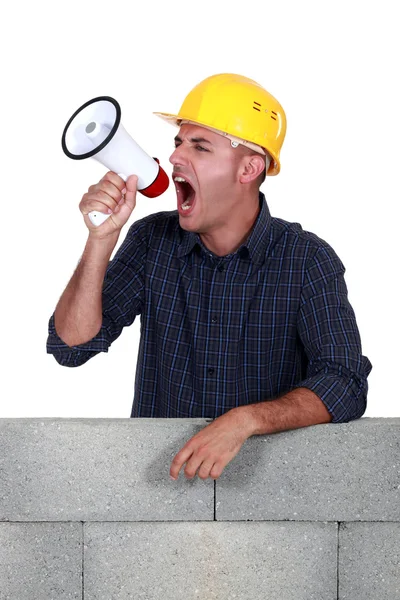 Craftsman shouting through a megaphone — Stock Photo, Image
