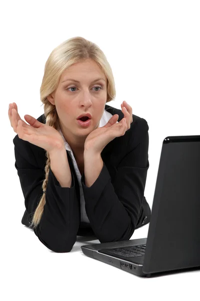 Mulher de negócios loira chocada sentou-se na frente do laptop — Fotografia de Stock