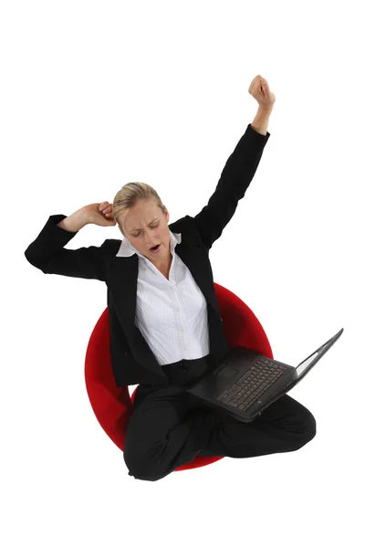 A sleepy woman working on her laptop — Stock Photo, Image