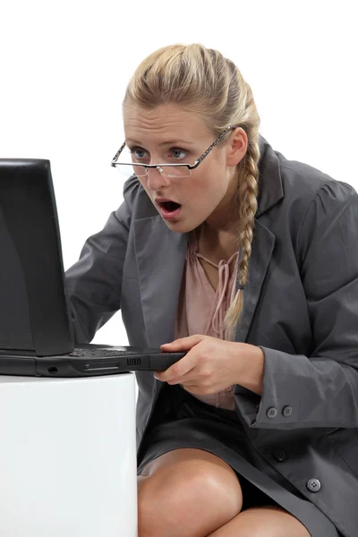 Блондинка-бизнесвумен с ноутбуком выглядит удивленной — стоковое фото