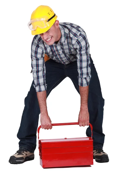 Laborer lifting heavy toolbox — Stock Photo, Image
