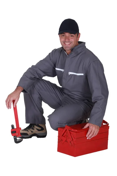 Encanador agachado por sua caixa de ferramentas — Fotografia de Stock