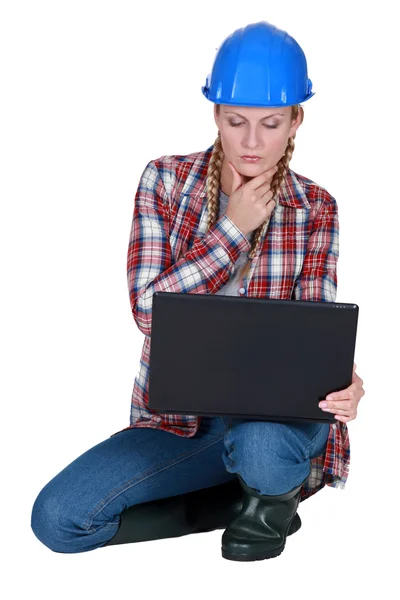 Construtora feminina pensativa com laptop — Fotografia de Stock