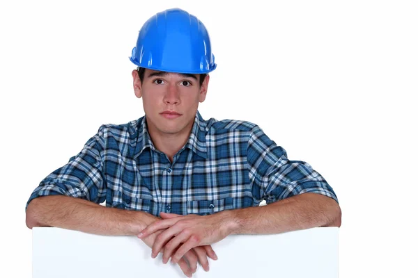 Sad builder stood with blank poster — Stock Photo, Image