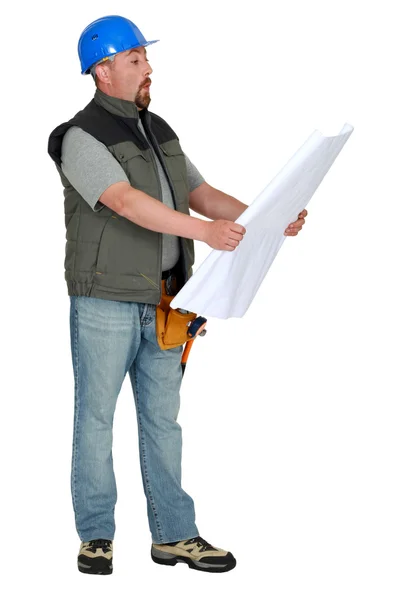 Tradesman examining a blueprint — Stock Photo, Image