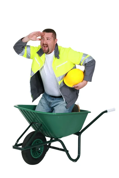 Trabalhador da construção num carrinho de mão — Fotografia de Stock