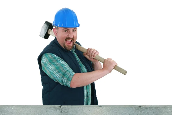 Bâtisseur frapper un mur avec un marteau de traîneau — Photo