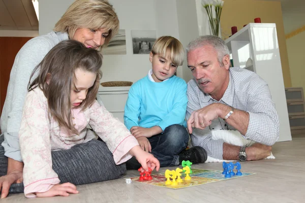 Elderly couple playing with their grandchildren — Stock Photo, Image