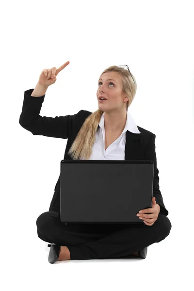 Woman sitting on the floor with her laptop and having a great idea Stock Picture