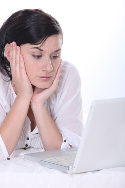 Young woman using a laptop computer clipart
