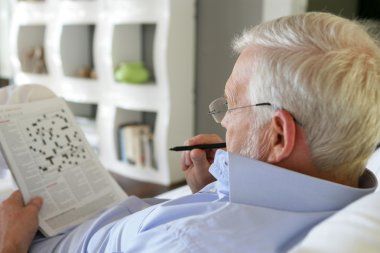 Senior man doing crossword clipart