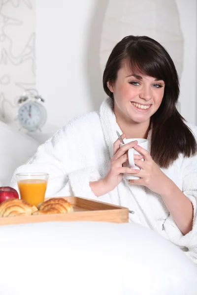 Fiatal nő együtt reggelizik az ágyban — Stock Fotó