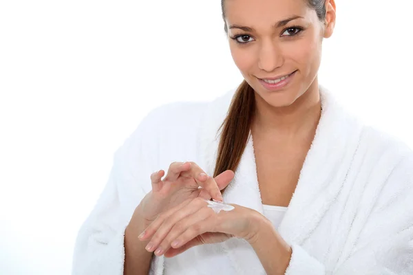 Γυναίκα στο μπάνιο ρόμπα εφαρμογή κρέμα χεριών — Φωτογραφία Αρχείου